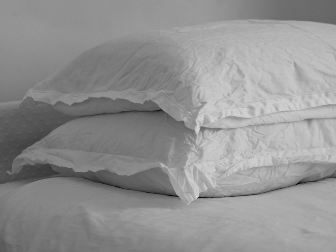 Black and white image of wrinkled linen pillow on a bed.